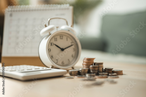 Photos Alarm clock, coins, calculator and calendar represent bill reminder, recurring payment schedule, budgeting, due dates, and smart personal finance management to avoid late fees
