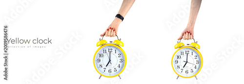 Cuadro en lienzo Female hand holding yellow alarm clock isolated on the white background