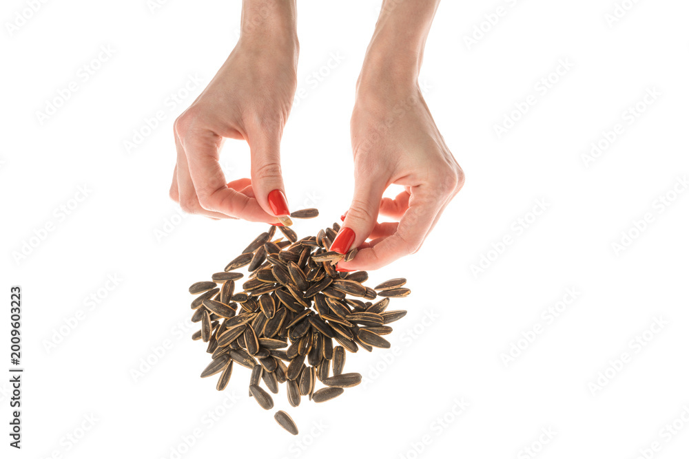 Fototapeta premium Female hand sunflower seeds on a white background isolation