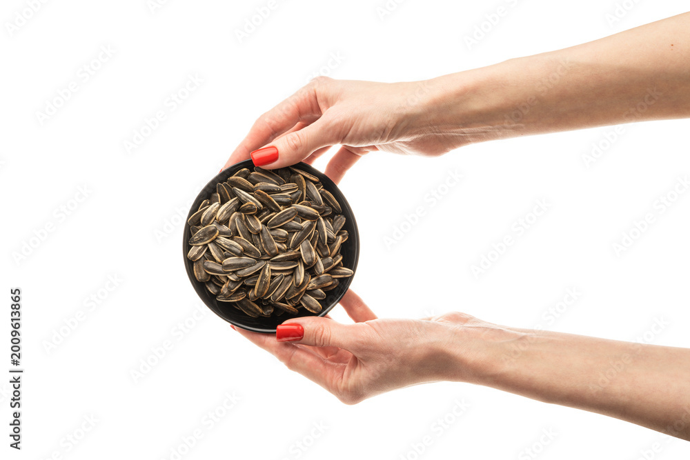 Fototapeta premium Female hand sunflower seeds on a white background isolation