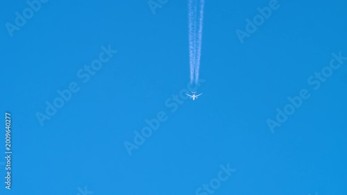 Commercial airplane cruising through the sky with a long white contrail. Symbol of modern air travel and freedom.