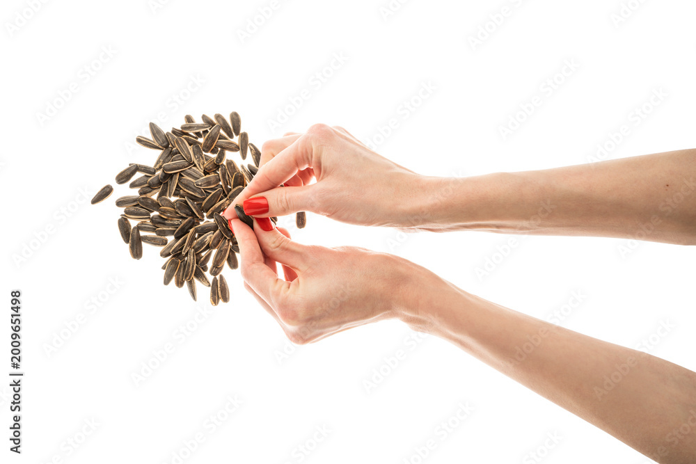 Fototapeta premium Female hand sunflower seeds on a white background isolation