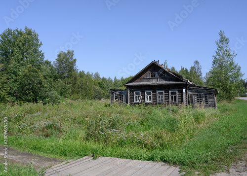 Abandoned dilapidated wooden village house by the road in Karelia