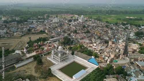 Wide aerial drone shot of Kapurthala city with green fields and gurudwara, Punjab India. Scenic aerial view of Kapurthala city showcasing greenery and Sikh temple in Punjab.