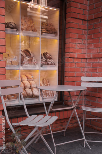 Foto Bakery storefront with outdoor seating and a display of fresh bread