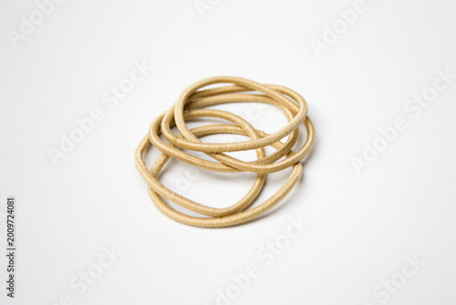 Heap of cream hair ties on white background