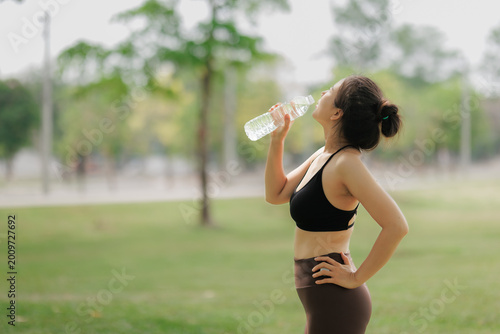 Fotografi Woman staying hydrated during outdoor yoga practice.