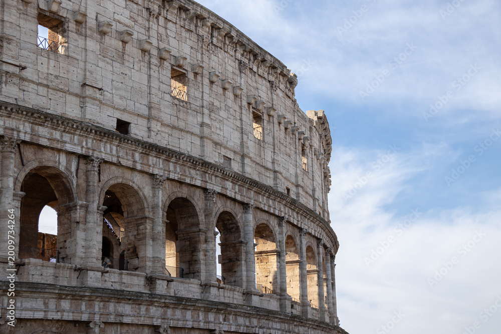 Obraz premium Colosseum arches detail in Rome, Italy with soft sky, ancient Roman architecture
