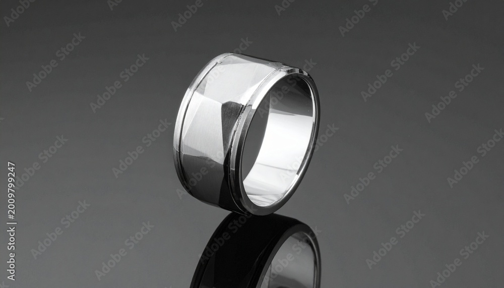 Fototapeta premium minimalist silver wedding ring floating with reflection on dark background