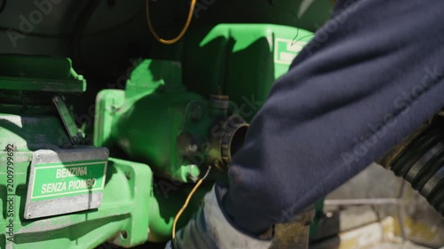 Man connects hose to gas station refueling tank, translation, unleaded gasoline