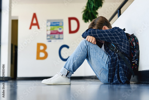 Foto Education, child and sad in classroom hallway for social isolation, bullying or mental health
