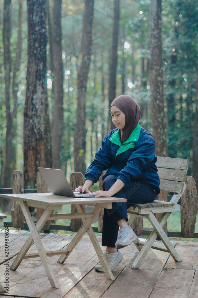 Fototapeta premium career woman sitting working using a laptop from anywhere