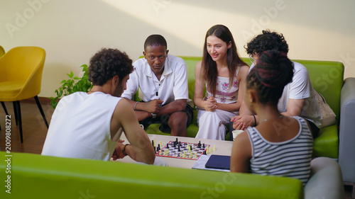 Cuadro en lienzo Indian young adult gen z male female group team sitting on sofa couch play chess