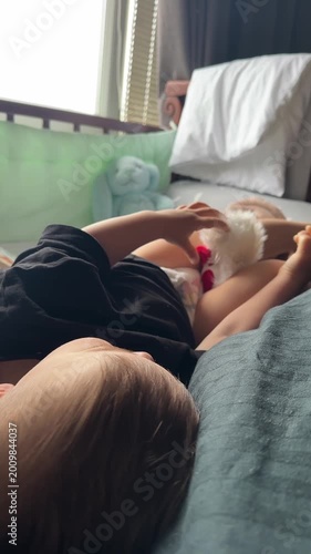 Child cuddling small white fluffy toy