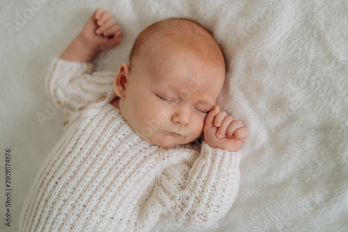 a newborn baby is sleeping, a sweet healthy baby's sleep on a white bed, space and room for text