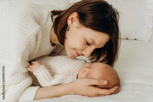 mother with a newborn baby, mother gently kisses and hugs a small child, mother and baby, motherhood