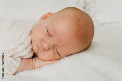 a newborn baby is sleeping, a sweet healthy baby's sleep on a white bed, space and room for text