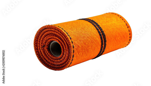 A vibrant orange and black rolled textile sits against a stark black background, showcasing intricate stitching and a textured surface.