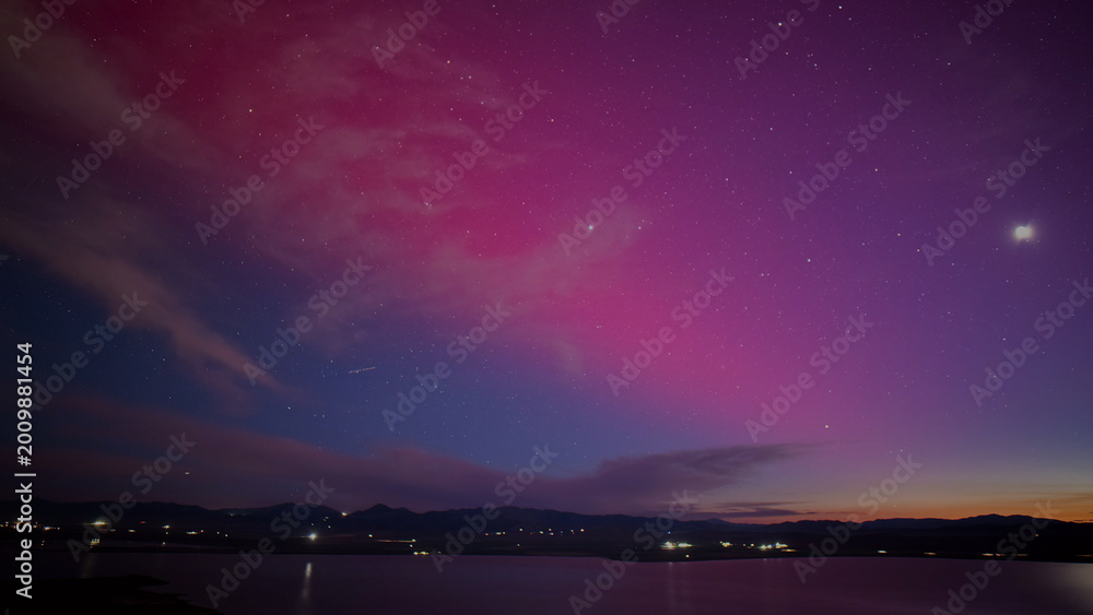 Fototapeta premium Vibrant night sky with stunning purple and pink aurora borealis, tranquil lake reflecting the colorful celestial display, serene twilight landscape for nature and travel themes