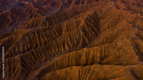 Fotografie Dramatic desert landscape, aerial view of arid badlands, rugged terrain with dee