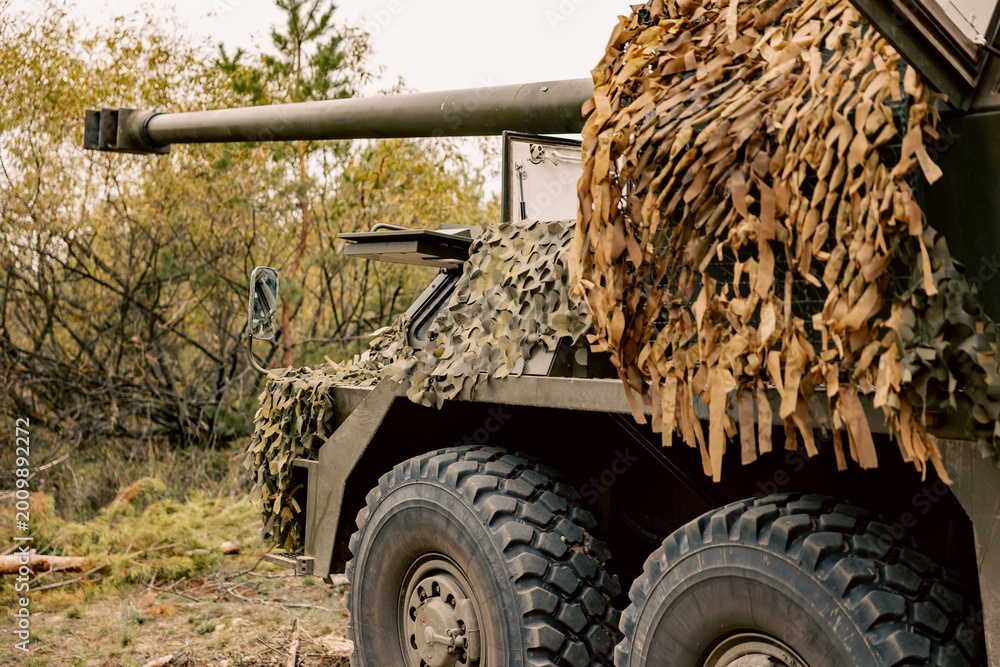 Fototapeta premium Camouflaged Artillery Position, self-propelled artillery mount in the forest on position.