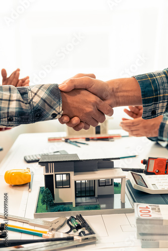 The teamwork of architects and engineers results in a collaborative house plan design; two experts shaking hands, a symbol of partnership.