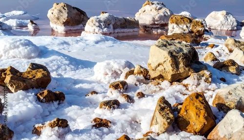 Frozen rocks on snowy beach landscape.