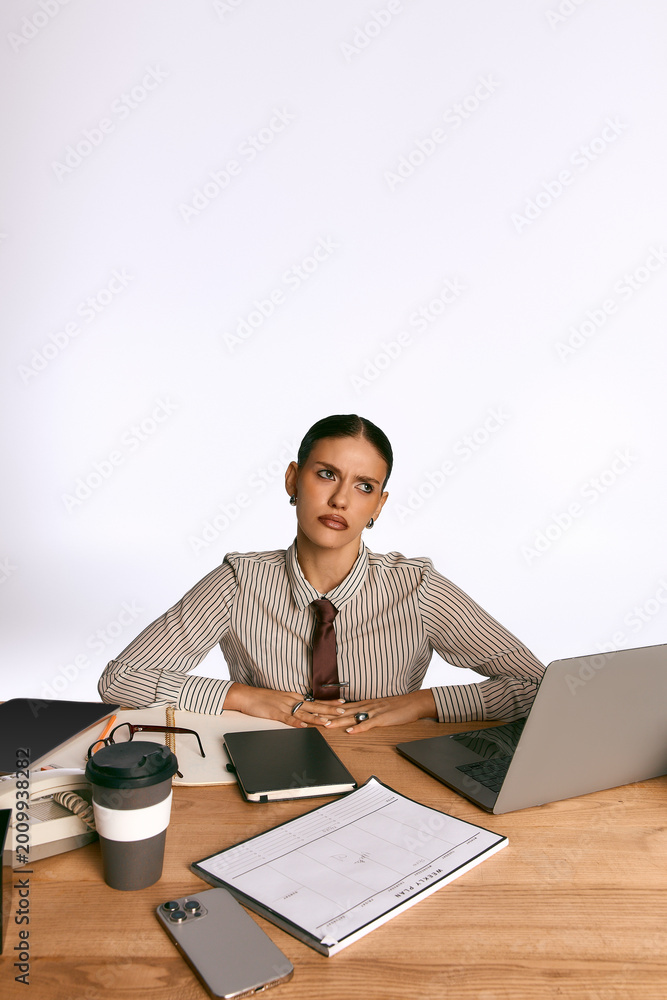 Fototapeta premium Stylish young woman in glasses works passionately in a modern office setting