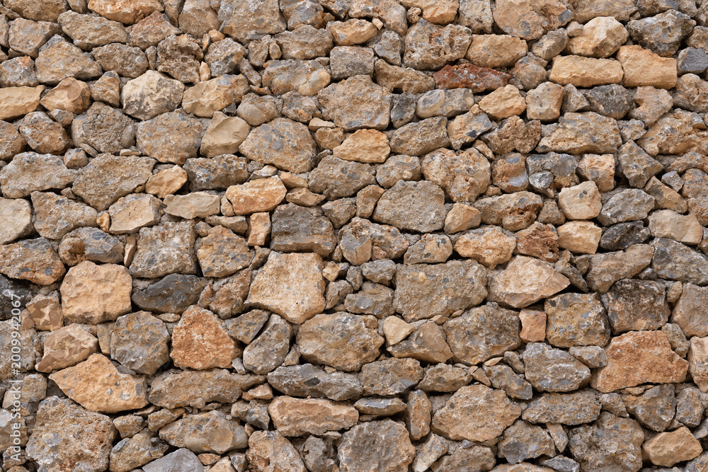 Fototapeta premium Stone wall showing rustic masonry texture background pattern