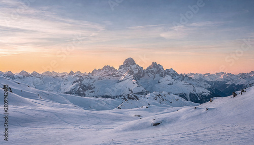 Fotografía Vast Snowy Mountain Landscape at Golden Hour with Colorful Sky Backdrop