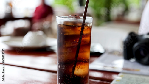 Bild auf Leinwand Cold Dark Soda with Ice and Straw at an Outdoor Restaurant