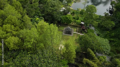 Aerial 4K view of an ancient stone temple in a lush tropical garden in Indonesia.
