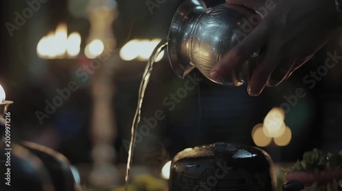 Hand Pouring Holy Water Over Shivling for Hindu Ritual Prayer Ceremony