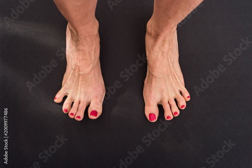 Yoga woman stretching feet on exercise mat at home, closeup photo. Toes splayed wide on mat, foot mobility and muscle control training demonstration