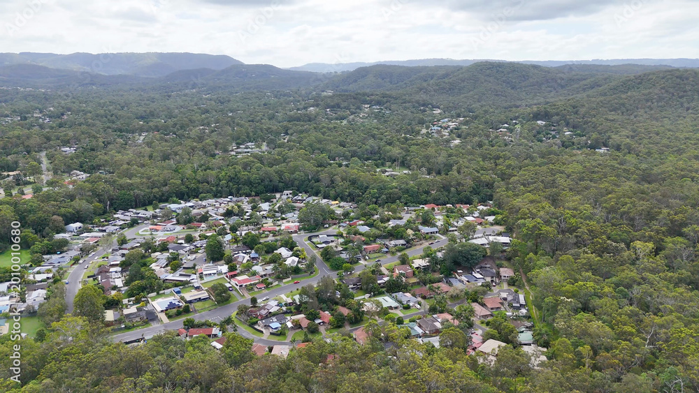Fototapeta premium Aerial View of Nerang Suburb Surrounded by Lush Green Forest