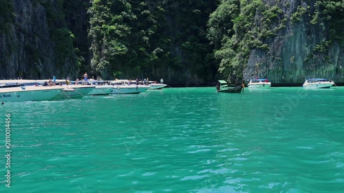 Views of lush green cliffs meeting turquoise waters in a serene coastal setting. 