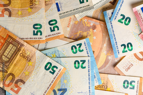 Close-up of mixed euro banknotes spread on table, representing European money, wealth, and economic concept.