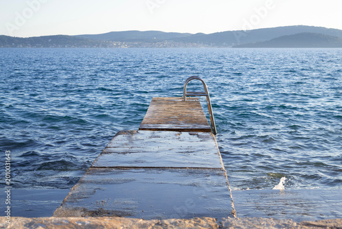 Foto Rustic Wooden Pier with Swimming Ladder at Punta Bajlo, Zadar
