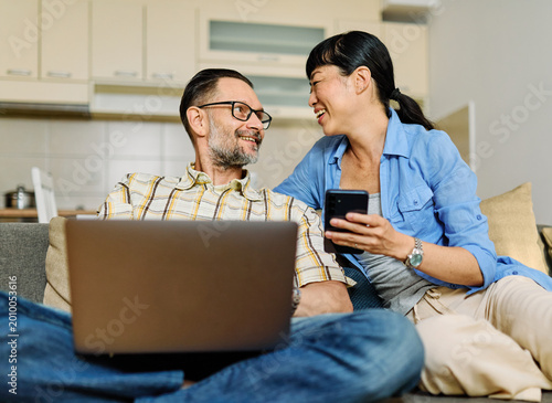 Foto Portrait of a lovely young couple using a laptop and a mobile phone  together an