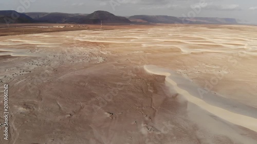 Aerial video flight over vast desert sand dunes and dry barren plains on socotra island yemen, perfect for travel documentaries, alien planet landscapes or nature exploration backgrounds