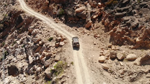 Panoramic aerial video of a car driving on a rugged mountain road in Socotra, showcasing adventurous travel and vast, untouched landscapes