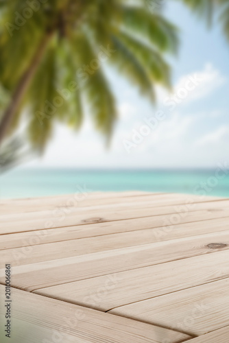 Bright empty wooden table with clean copy space for product placement in the foreground. In the softly blurred background, peaceful outdoor scene with water such as lake or sea and blue sky.