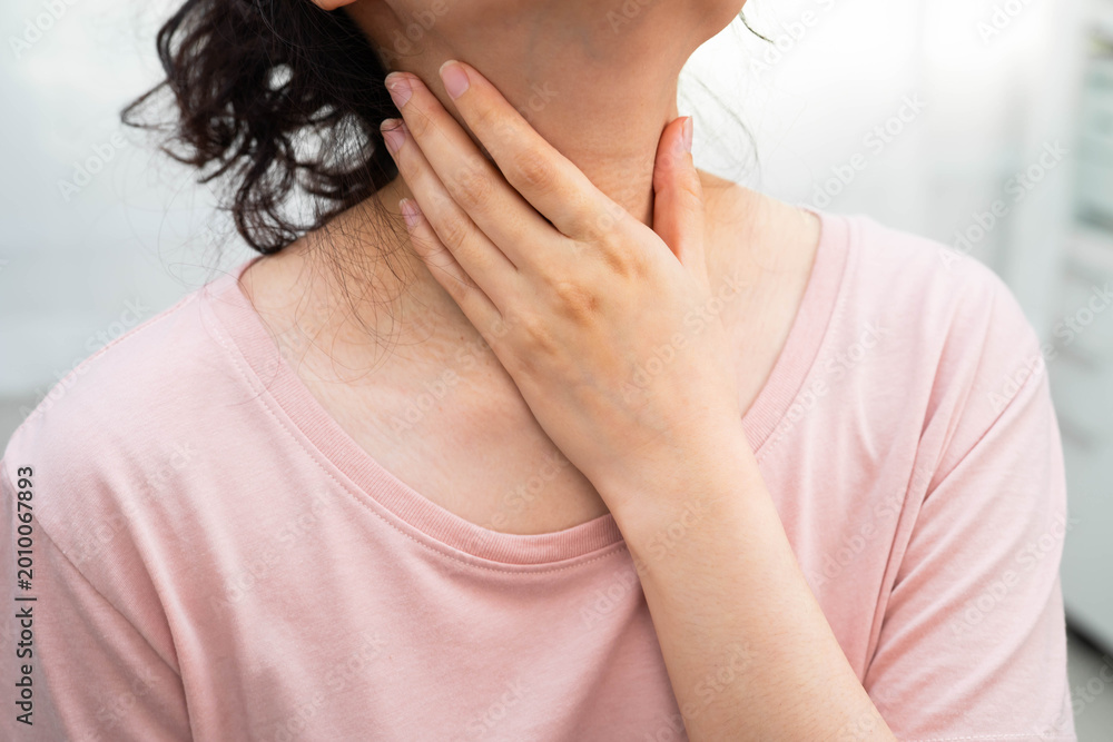 Fototapeta premium Asian woman touching her neck and throat for thyroid gland problem.