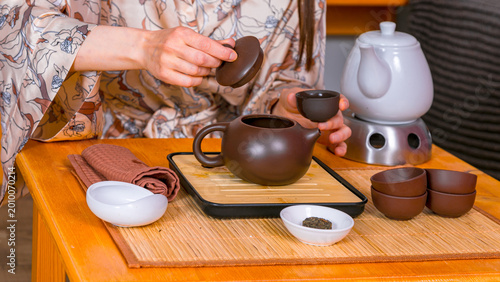 Tablou pe pânză Woman preparing Chinese tea ceremony with clay teapot