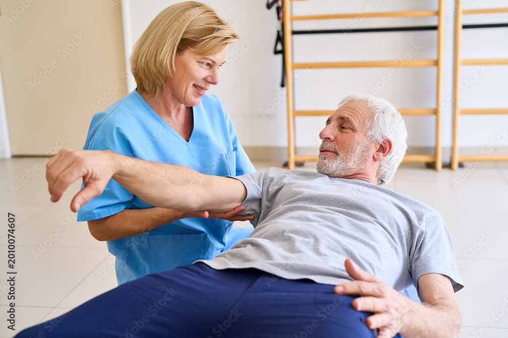 Obraz premium Senior Man Receiving Arm Physiotherapy From Female Therapist In Rehab Center Indoor Rehabilitation Exercise For Recovery And Mobility