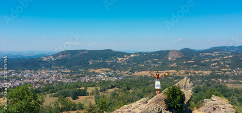 woman standing on rock enjoying panoramic valley view, freedom, inspiration and achievement concept