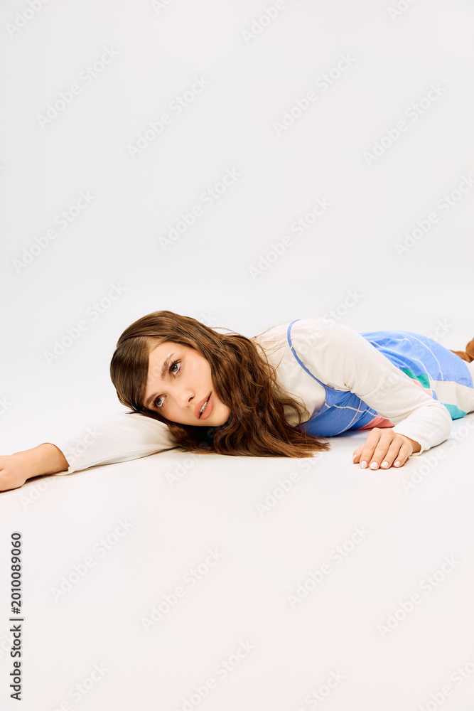 Fototapeta premium Striking young woman posed elegantly on the floor in vibrant fashion attire showcasing beauty