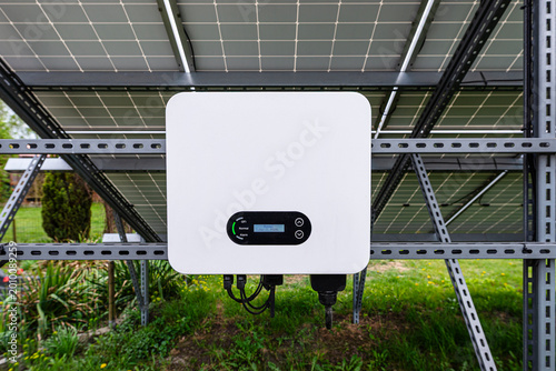 Solar inverter converting energy from photovoltaic panels in garden