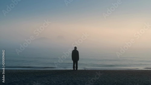 Solitary figure standing on a beach contemplating the vast ocean. Exploring the profound principles of MA philosophy.