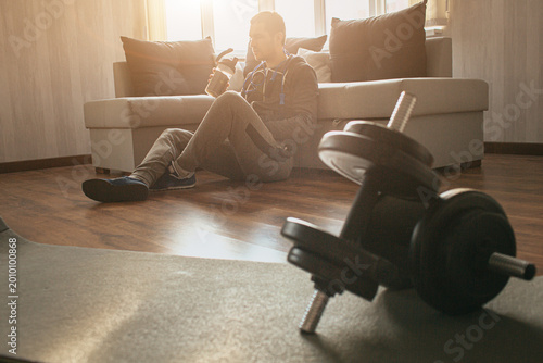 Fotografija Young ordinary man go in for sport at home